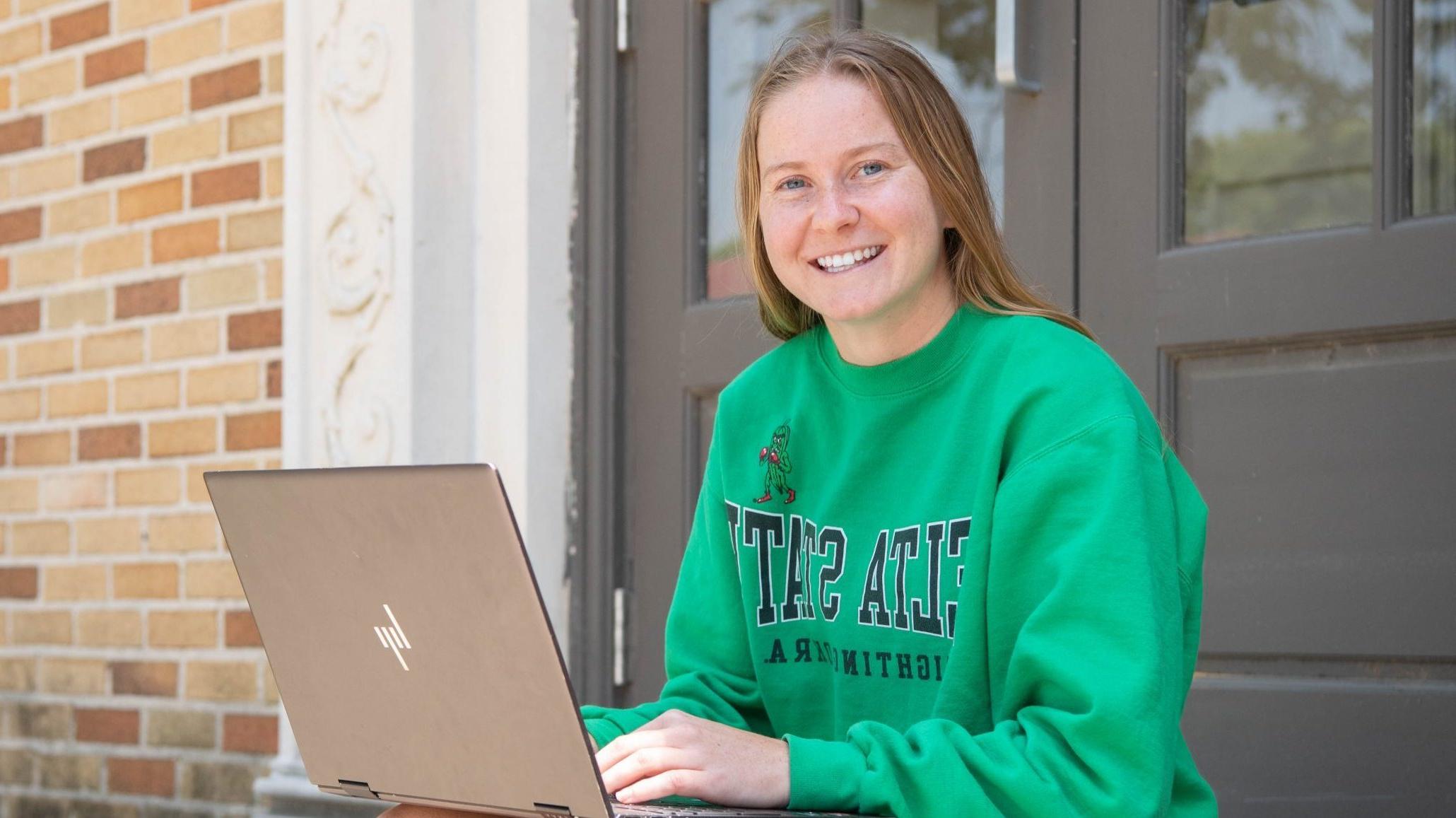 Student on laptop in Delta State hoodie, completing assignments.